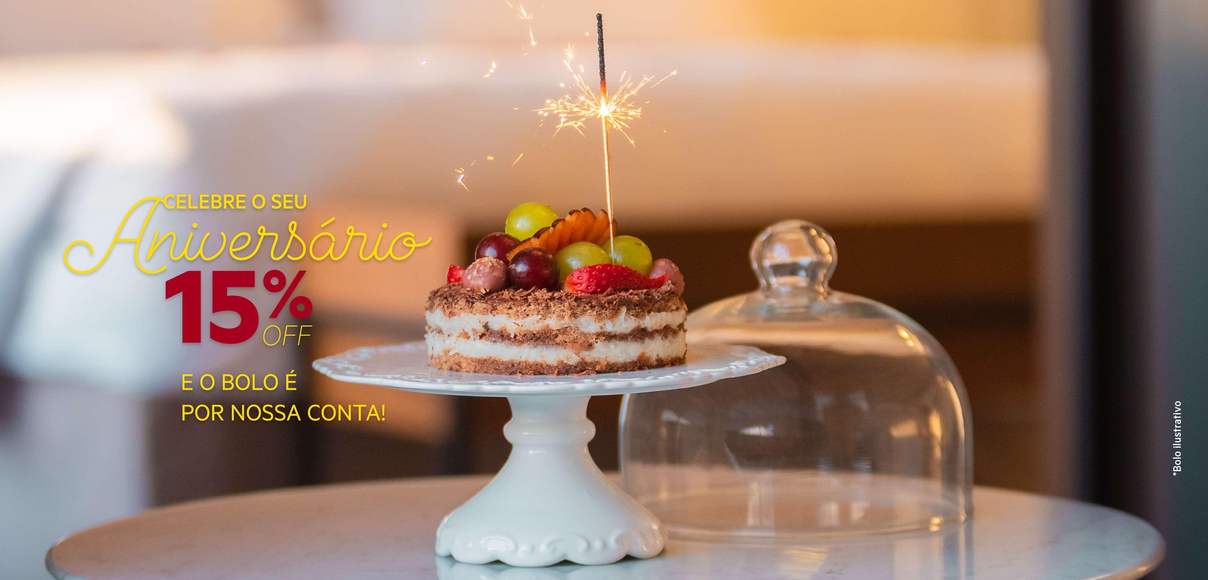 Royal Tulip Brasilia Alvorada Hotel Exterior photo The photo shows a decorated cake placed on a white cake stand. The cake is adorned with various fruits, including strawberries and grapes, and has a sparkler candle on top, creating a festive look. A glass dome is positioned beside the cake. Addition